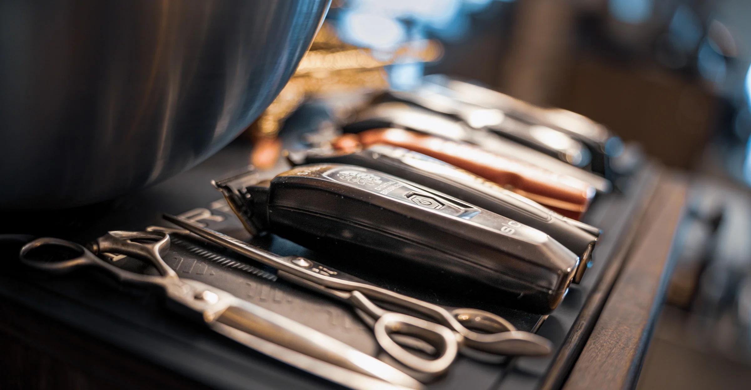 Clippers and shears laid out in a row on a barber's station