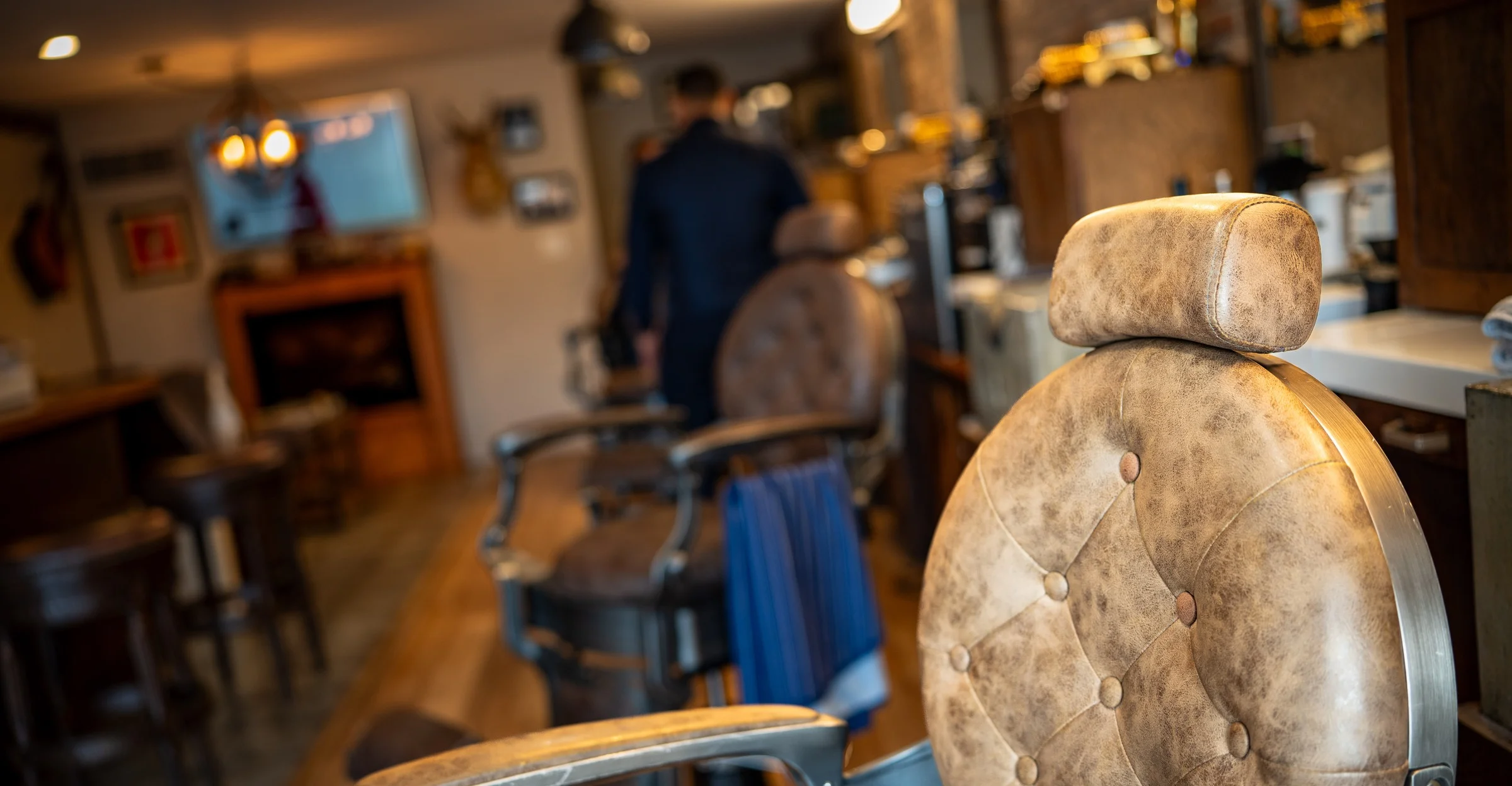 A tufted leather barber chair on the floor of the Barley and Mane shop