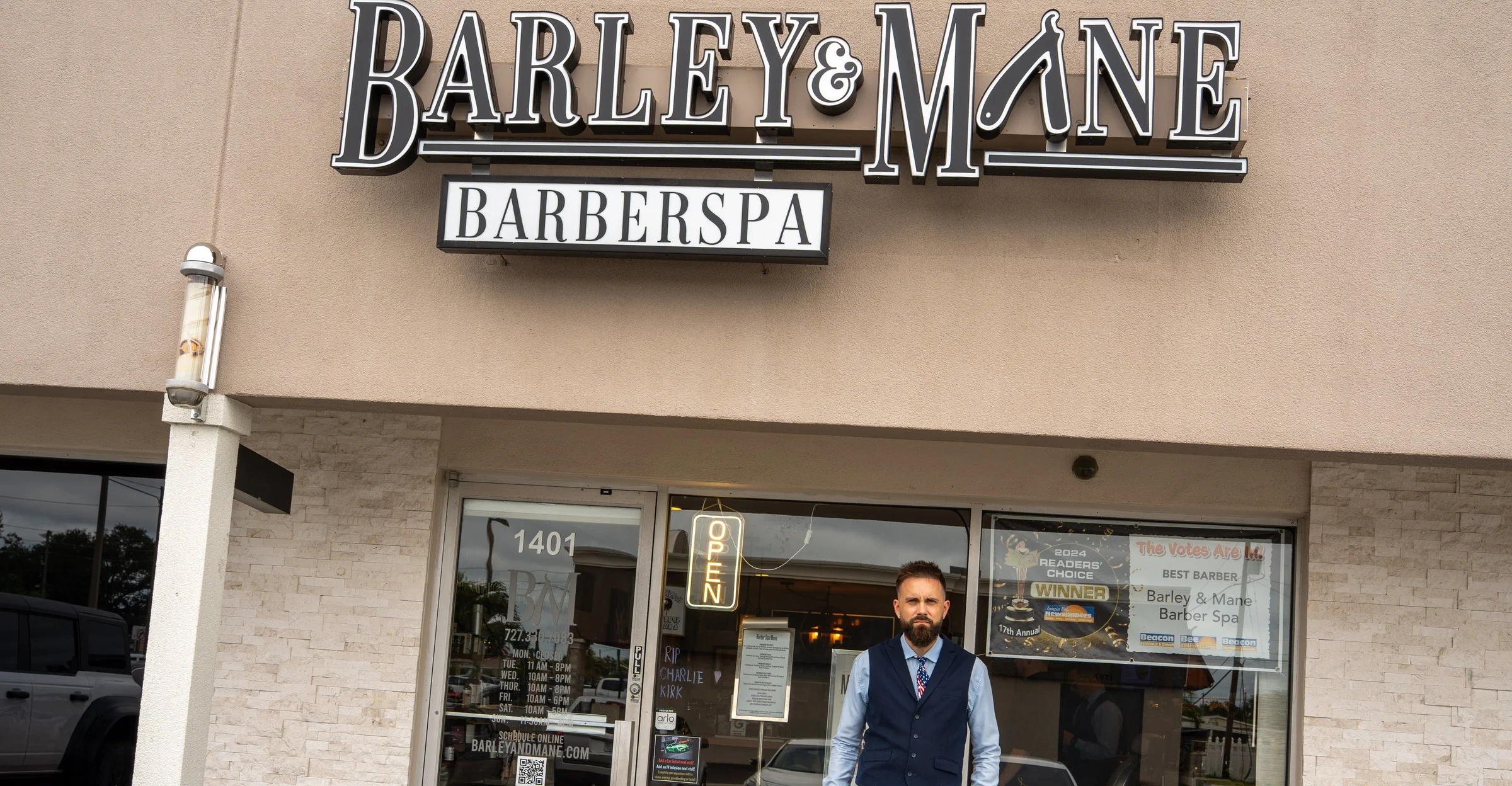 The Barley and Mane Barberspa storefront at 1401 Main Street in downtown Dunedin, the owner standing at the door