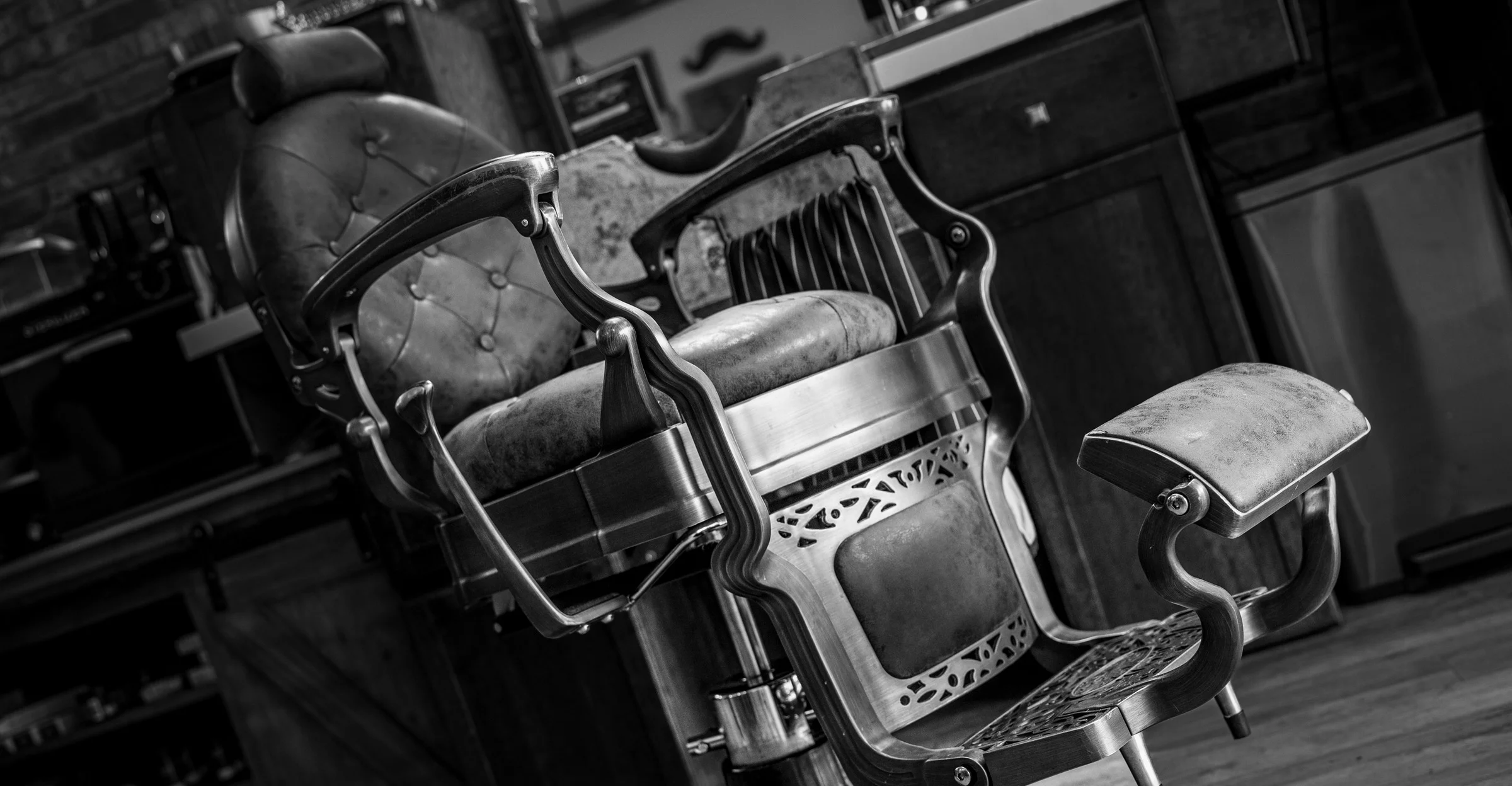 Two vintage barber chairs in black and white on the shop floor