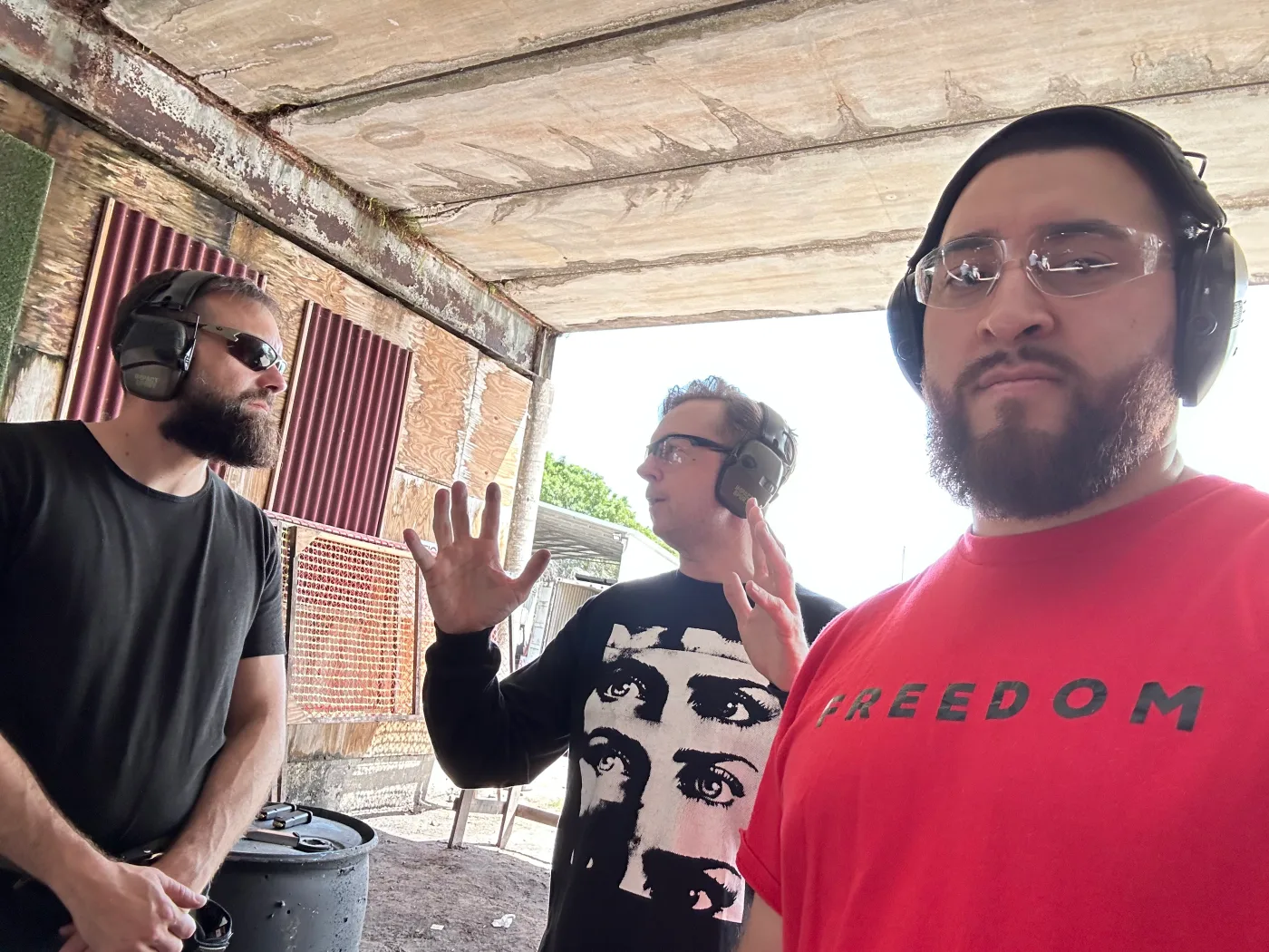 Three members of the Barley and Mane team in ear protection at an outdoor shooting range