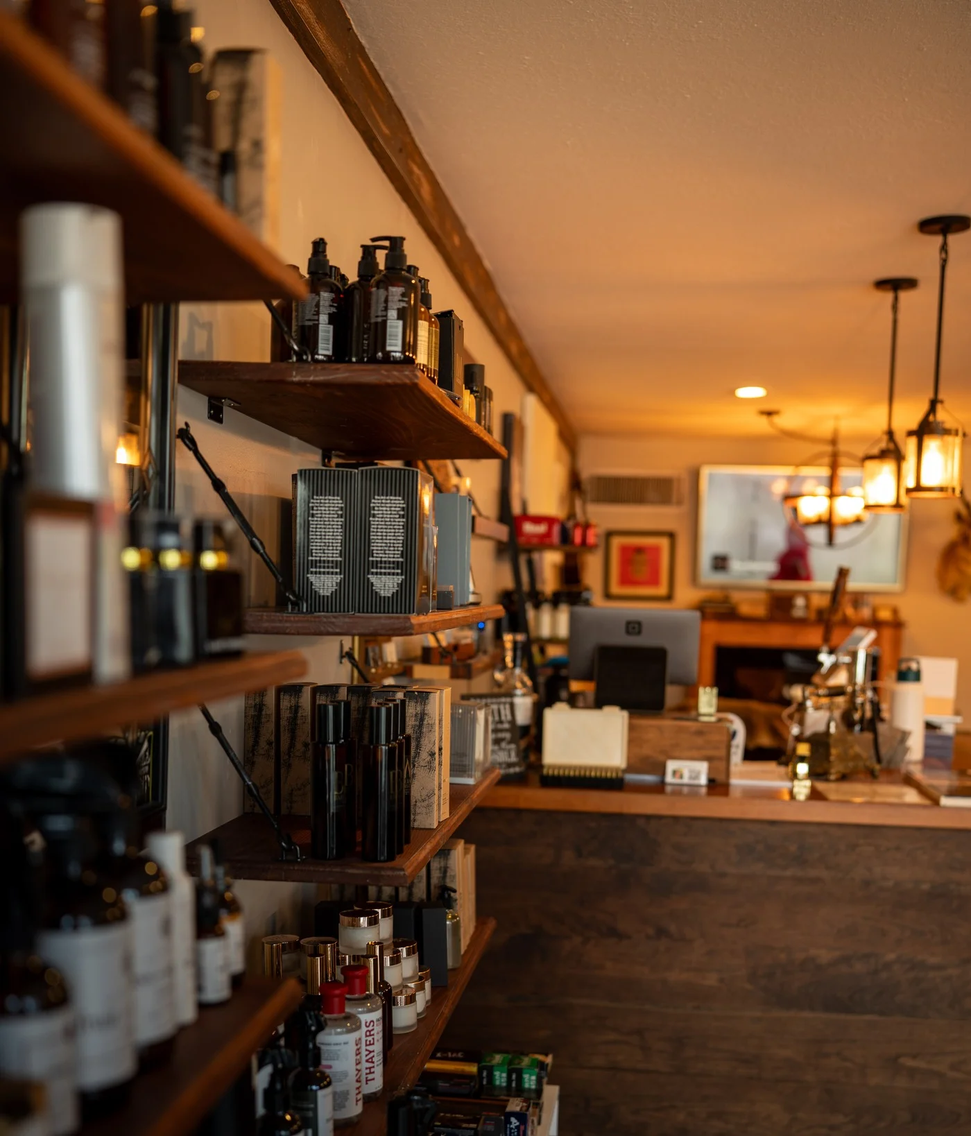 The front desk and grooming product shelves inside Barley and Mane, lit warm