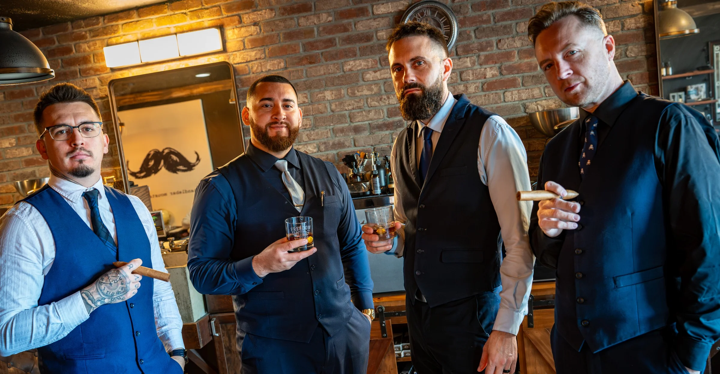 Four Barley and Mane barbers in vests and ties sharing whiskey and cigars inside the shop