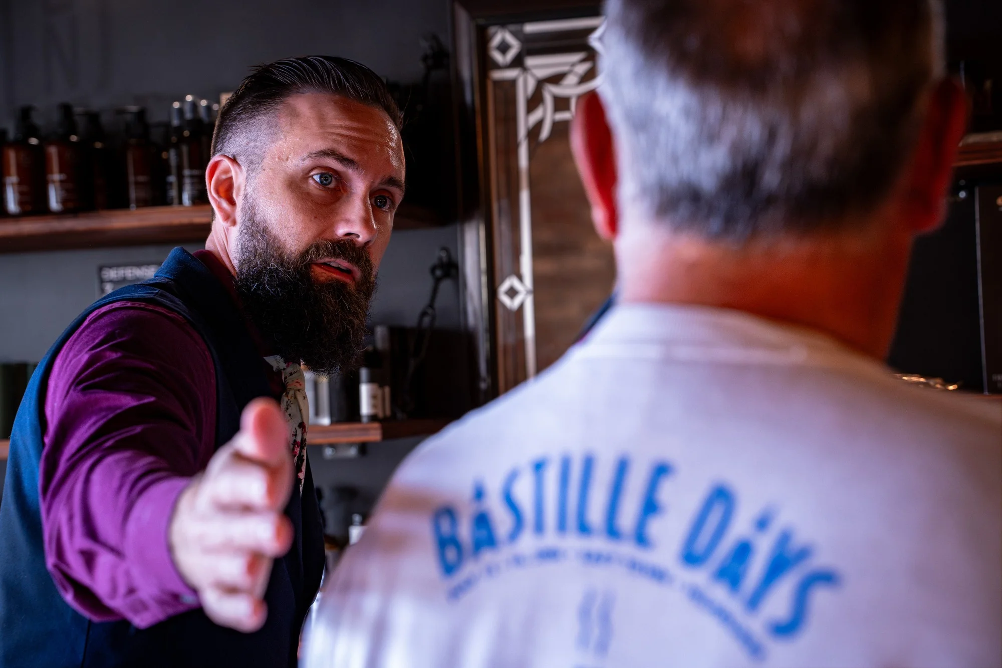 Owner Ryan holding out a hand to welcome a client into the shop
